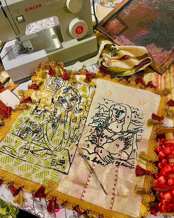 Pillow cover with silkscreened figures on a table next to a sewing machine.